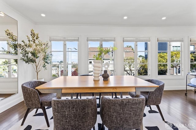 dining area featuring plenty of natural light, wood finished floors, and ornamental molding