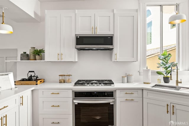 kitchen featuring stainless steel appliances, light countertops, and white cabinetry