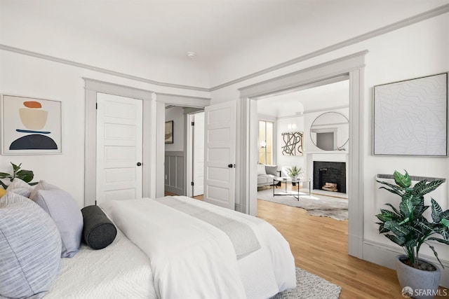 bedroom with a fireplace and light wood-style flooring