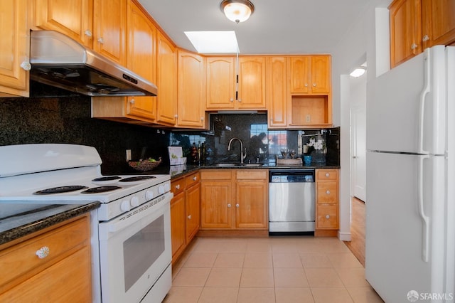 kitchen featuring sink, backsplash, dark stone counters, light tile patterned floors, and white appliances