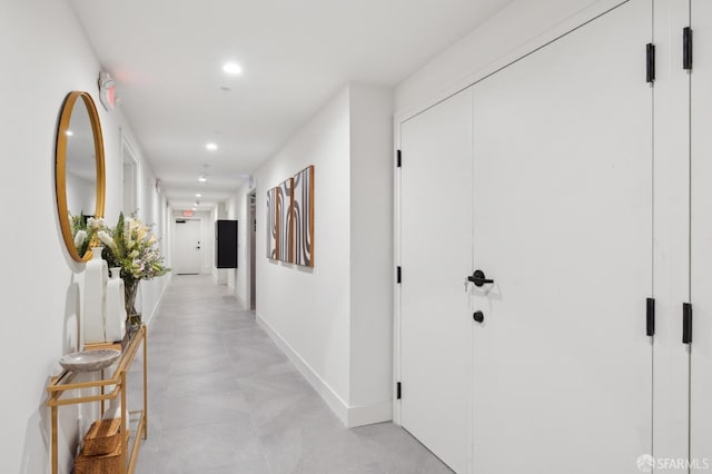 hall with baseboards and recessed lighting