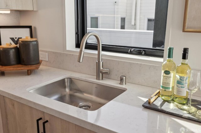 room details with light stone counters and a sink