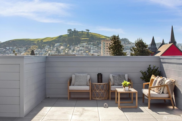 view of patio / terrace with fence and a mountain view