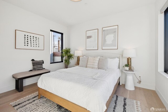 bedroom featuring baseboards and wood finished floors