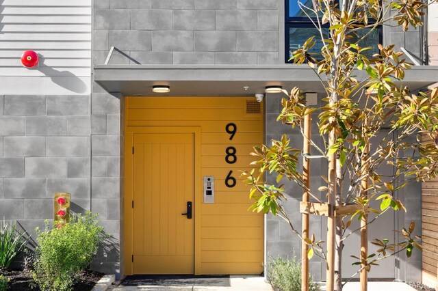 doorway to property featuring concrete block siding