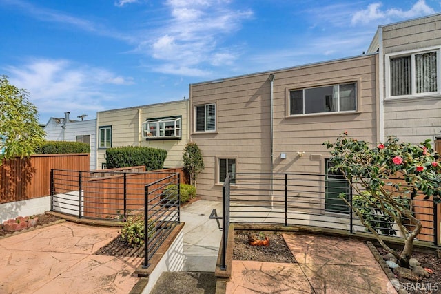 view of front of house featuring a patio area and fence