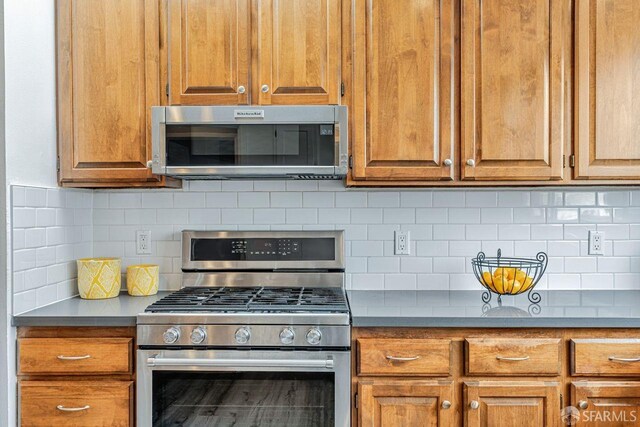 kitchen featuring appliances with stainless steel finishes, brown cabinets, and backsplash