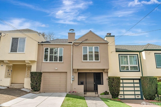 townhome / multi-family property with concrete driveway, a chimney, roof with shingles, an attached garage, and stucco siding