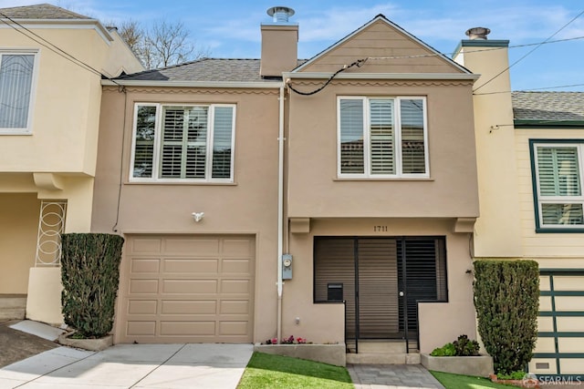 townhome / multi-family property with an attached garage, a chimney, concrete driveway, and stucco siding