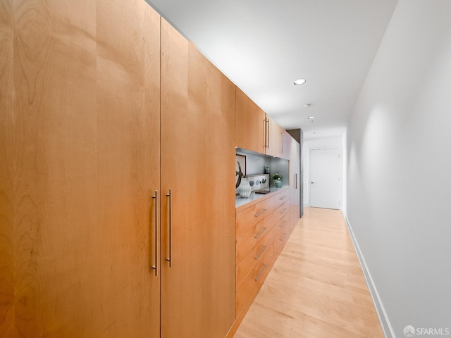 hall featuring recessed lighting, light wood-style flooring, and baseboards