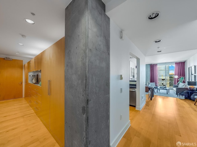 hall featuring light wood-type flooring, baseboards, and recessed lighting