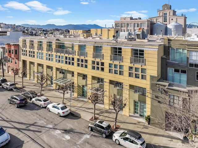 view of property with uncovered parking and a mountain view