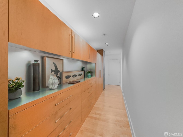 hall featuring recessed lighting, baseboards, and light wood finished floors