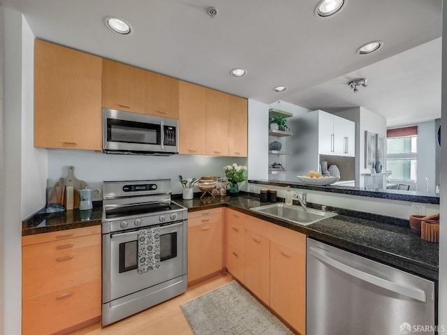 kitchen featuring recessed lighting, a sink, appliances with stainless steel finishes, light brown cabinetry, and light wood finished floors