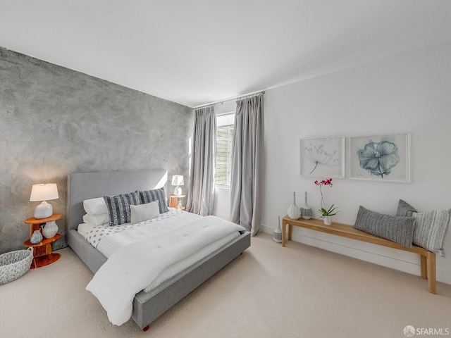 bedroom featuring an accent wall and carpet