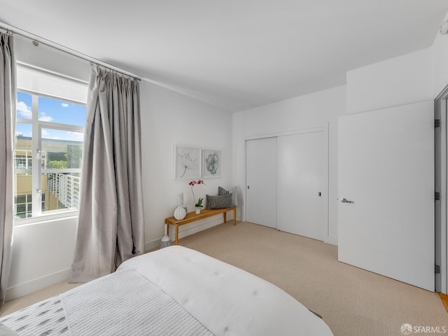 bedroom featuring a closet and light colored carpet