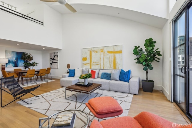 239 8th St Unit 14, San Francisco, CA 94103 - living area featuring wood finished floors, baseboards, a ceiling fan, and a high ceiling