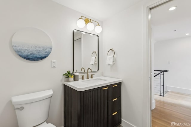 239 8th St Unit 14, San Francisco, CA 94103 - bathroom with vanity, toilet, wood finished floors, baseboards, and recessed lighting