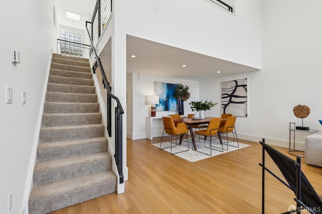 239 8th St Unit 14, San Francisco, CA 94103 - staircase with wood finished floors, a high ceiling, baseboards, and recessed lighting