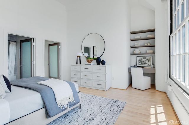 151 Alice B Toklas Pl Unit 610, San Francisco, CA 94109 - bedroom featuring a towering ceiling, light wood finished floors, and baseboards