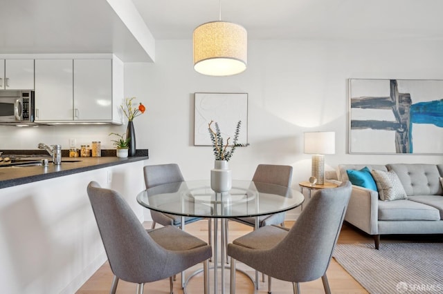 dining area with light hardwood / wood-style floors and sink