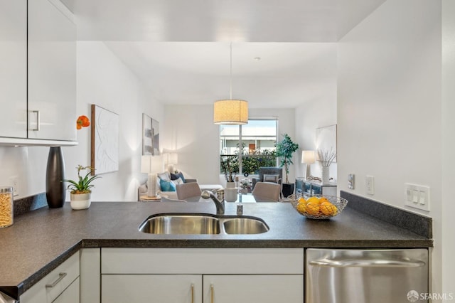 kitchen featuring kitchen peninsula, white cabinetry, stainless steel dishwasher, and sink