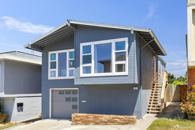 67 Castillejo Dr, Daly City, CA 94015 - view of front of house with stairway, a garage, concrete driveway, and stucco siding