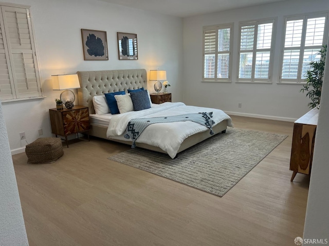 bedroom with multiple windows and light wood-type flooring