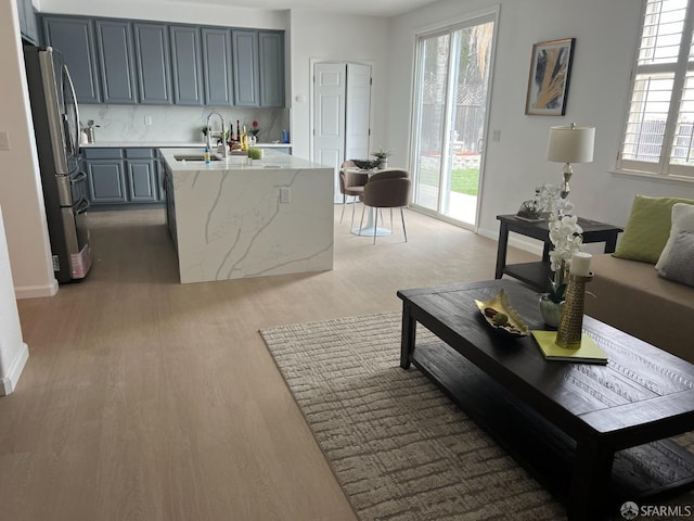 living room featuring sink and light hardwood / wood-style floors