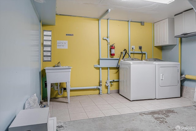 laundry room featuring light tile patterned flooring, a sink, and separate washer and dryer