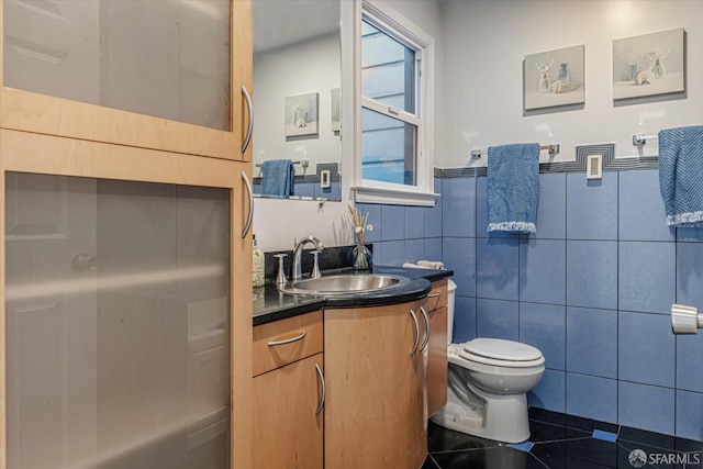 bathroom featuring tile patterned flooring, tile walls, vanity, and toilet