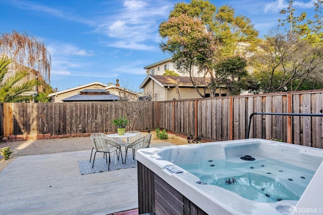 view of patio / terrace with outdoor dining area, a fenced backyard, and a hot tub