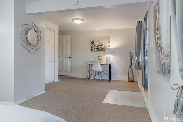 bedroom featuring light tile patterned flooring, baseboards, and light colored carpet