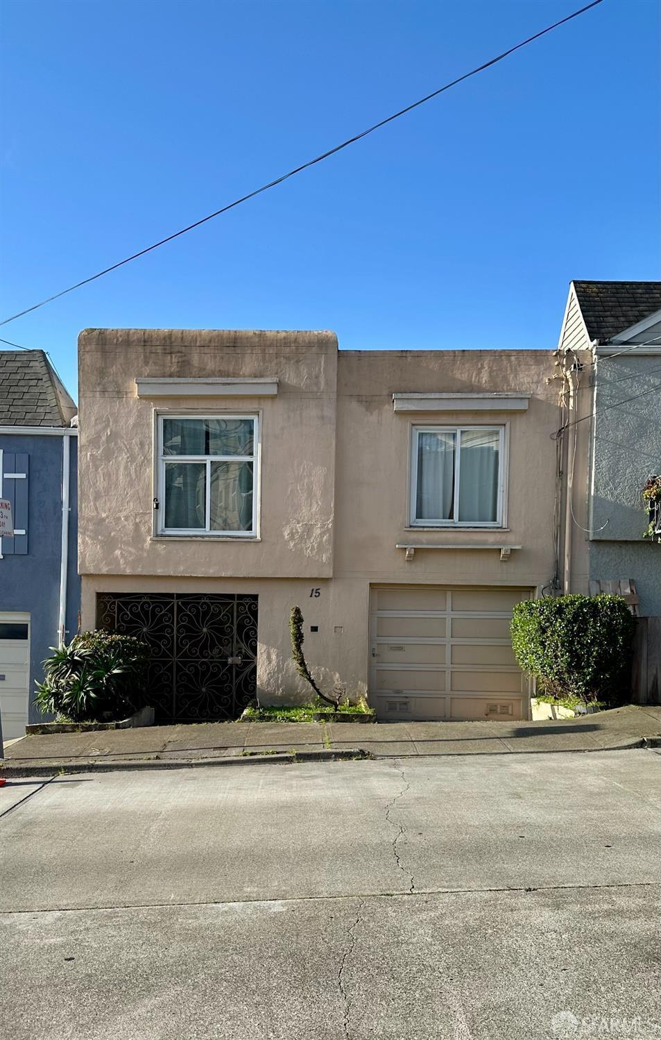 15 Venus St, San Francisco, CA 94124 - view of front of house with an attached garage, stucco siding, and driveway