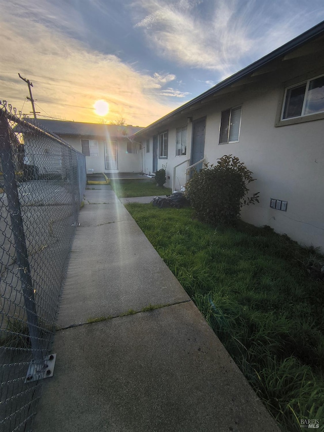 property exterior at dusk featuring a yard