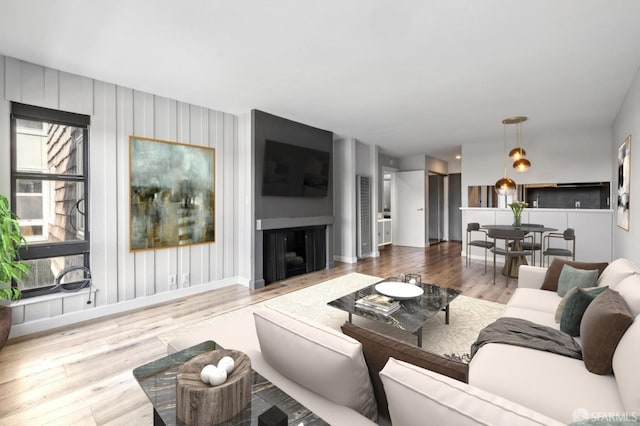 living room with baseboards, wood finished floors, and a fireplace