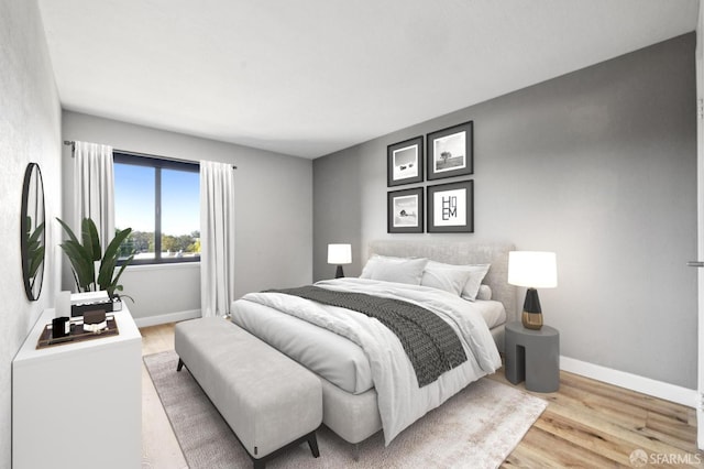 bedroom with baseboards and light wood-type flooring