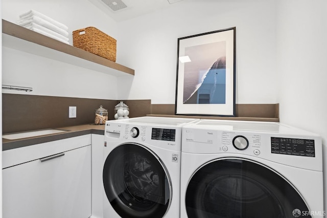 washroom featuring cabinets and washer and dryer