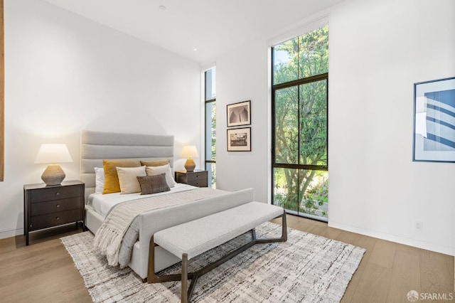 bedroom with light hardwood / wood-style floors and expansive windows