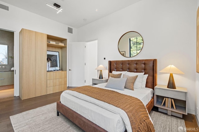 bedroom featuring dark hardwood / wood-style flooring and connected bathroom