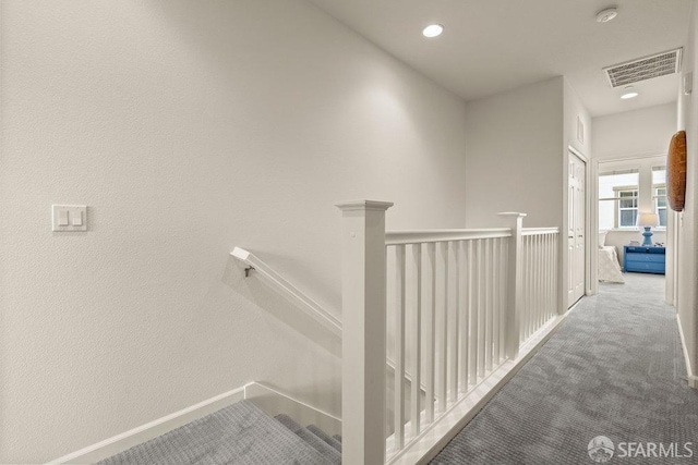 hallway featuring visible vents, baseboards, an upstairs landing, carpet, and recessed lighting