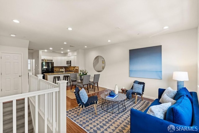 living room featuring recessed lighting, baseboards, and wood finished floors