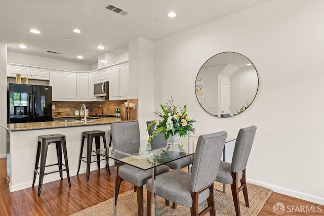 dining area featuring baseboards, recessed lighting, wood finished floors, and visible vents