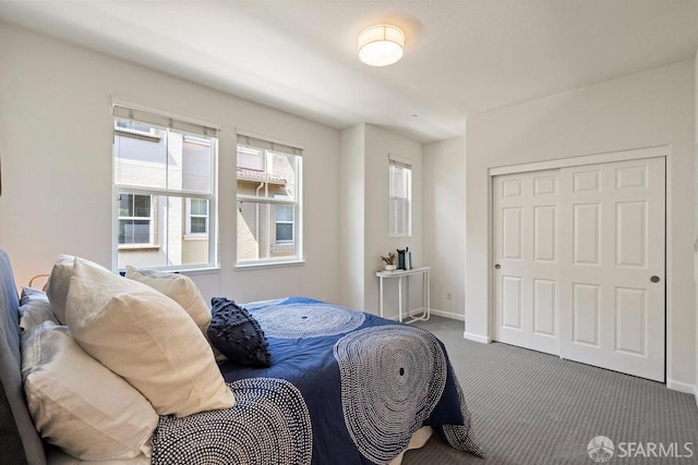bedroom with baseboards, carpet, and a closet