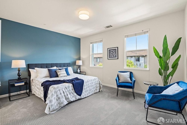 carpeted bedroom featuring baseboards and visible vents