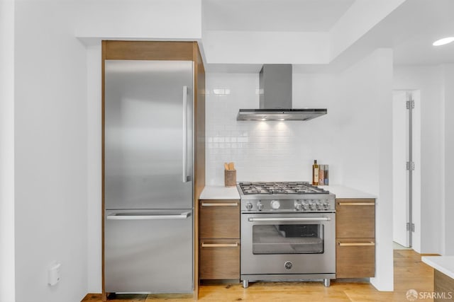 425 1st St Unit 1902, San Francisco, CA 94105 - kitchen with high quality appliances, wall chimney exhaust hood, tasteful backsplash, brown cabinetry, and light countertops