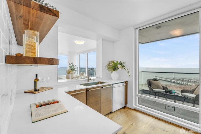425 1st St Unit 1902, San Francisco, CA 94105 - kitchen featuring stainless steel dishwasher, light countertops, light wood-style flooring, modern cabinets, and a wall of windows
