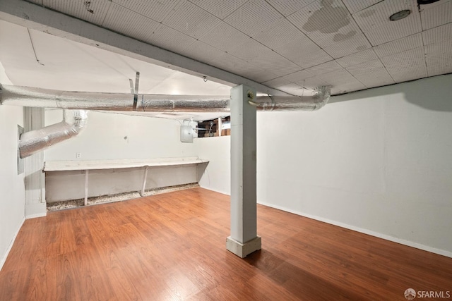 basement featuring electric panel and hardwood / wood-style floors