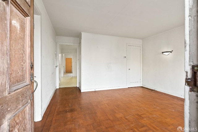 spare room featuring dark parquet flooring