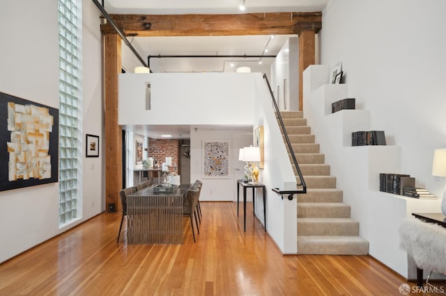 foyer with beam ceiling, light hardwood / wood-style floors, and track lighting